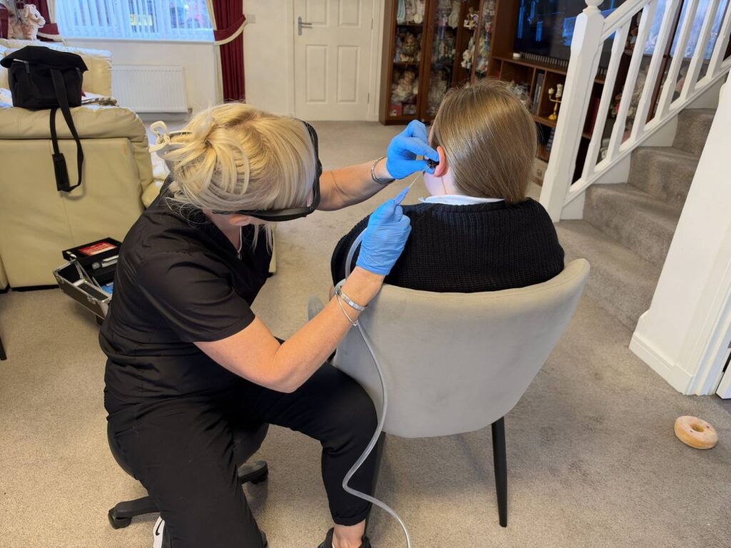 Jackie carrying out ear wax removal at a client's home