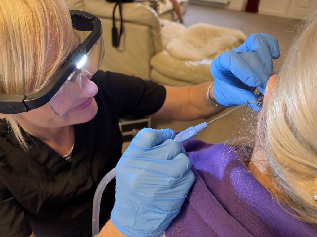 Close-up of Jackie using a microsuction probe with a headlamp