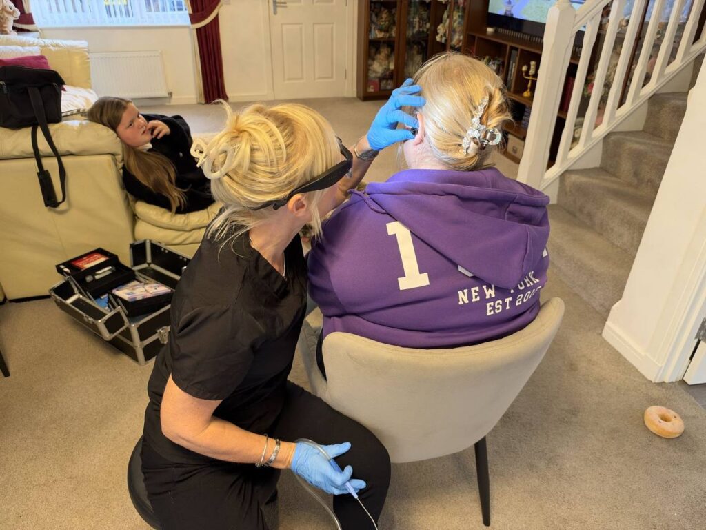 Jackie carrying out microsuction ear wax removal in a client's living room